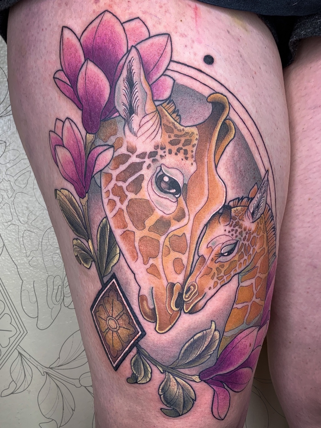 Tatouage néotraditionnel girafe et magnolia en couleur sur la cuisse