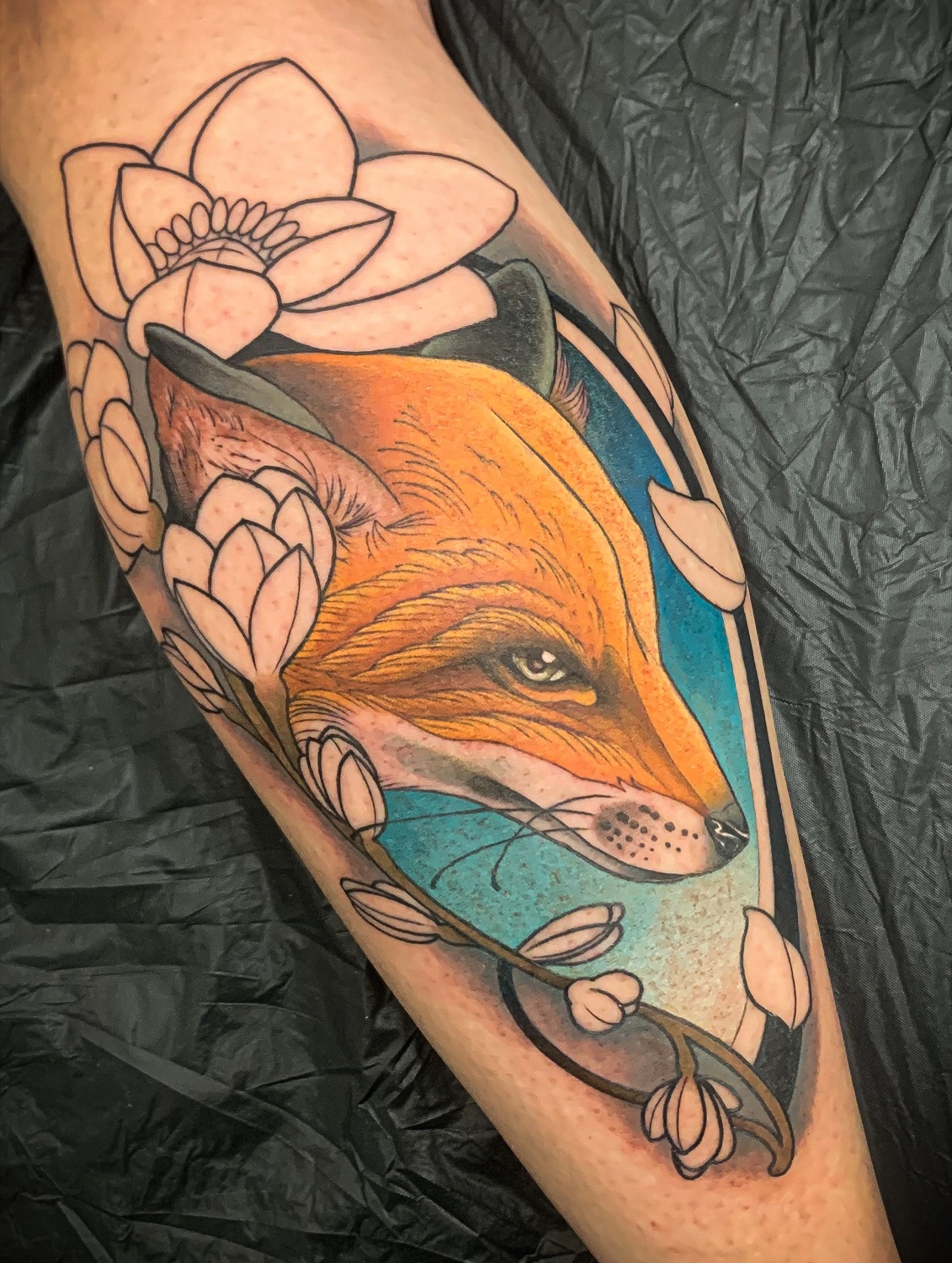 Tatouage néotraditionnel renard et lotus en couleur sur le mollet
